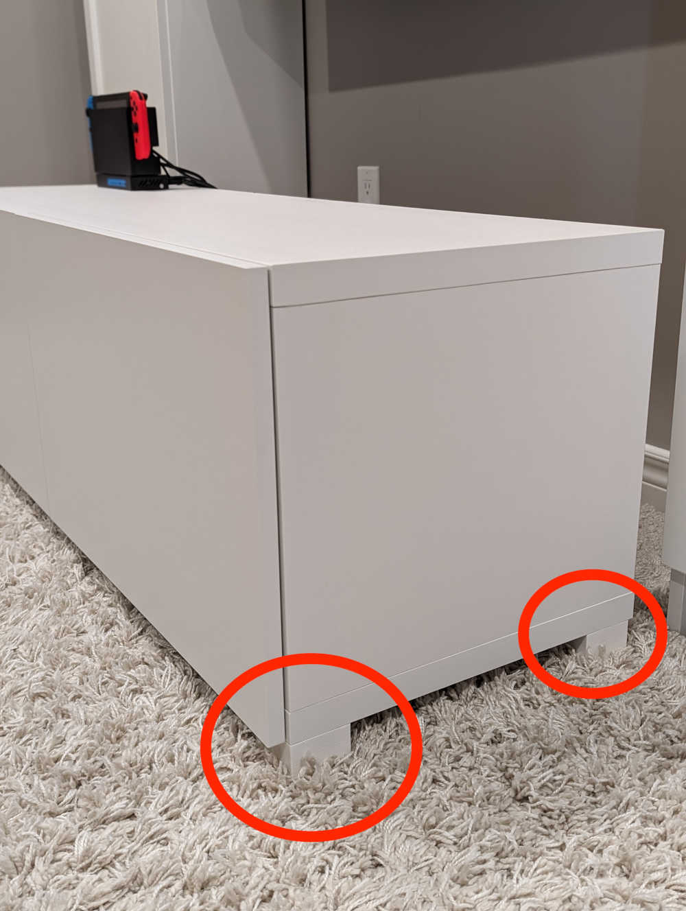 A TV cabinet with legs highlighted by red circle annotations